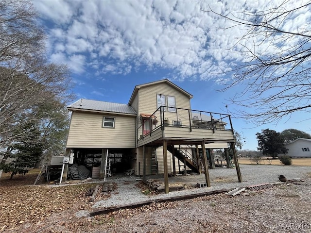 exterior space with driveway, stairway, metal roof, a deck, and a carport