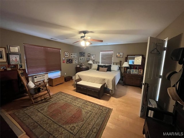 bedroom with visible vents, light wood-type flooring, cooling unit, and a ceiling fan