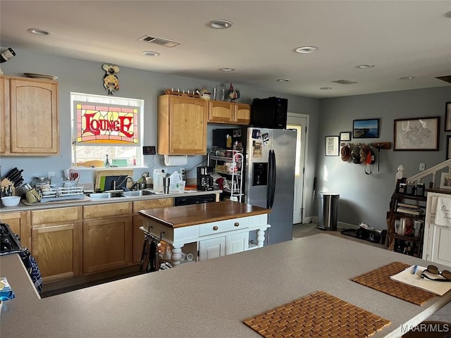 kitchen with stainless steel refrigerator with ice dispenser, recessed lighting, light countertops, visible vents, and a sink