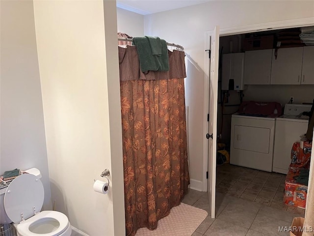 bathroom featuring toilet, curtained shower, tile patterned flooring, and washing machine and clothes dryer