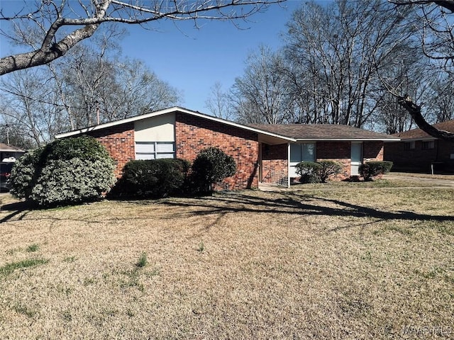 view of front facade with a front yard and brick siding