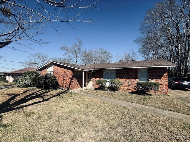 ranch-style house featuring brick siding and a front lawn