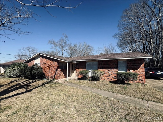 ranch-style home featuring brick siding and a front lawn