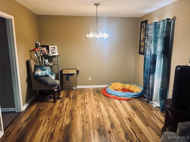 game room featuring a chandelier, baseboards, and wood finished floors