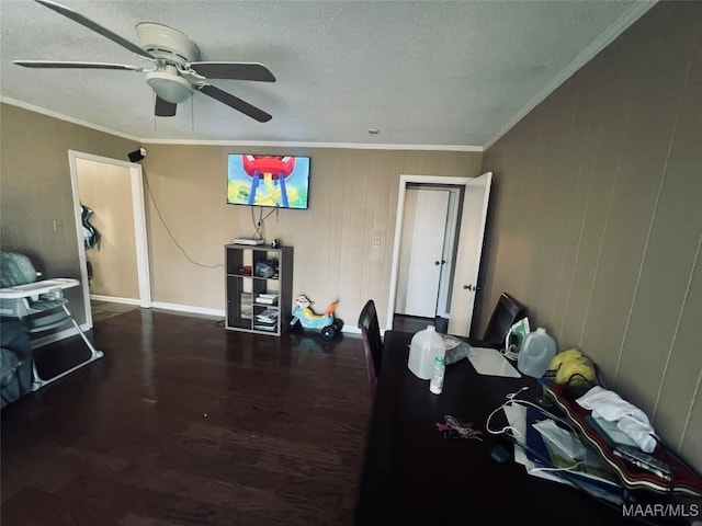 bedroom with ceiling fan, a textured ceiling, wood finished floors, baseboards, and crown molding