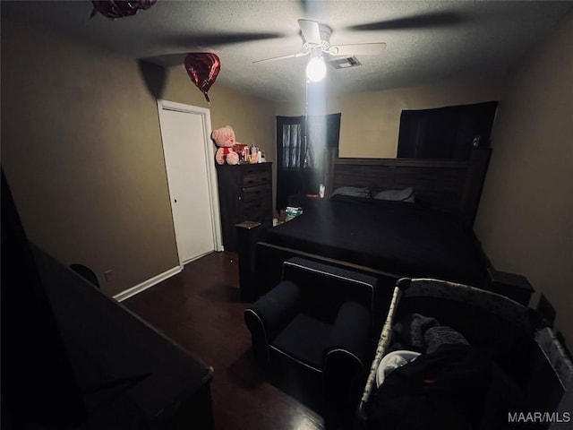 bedroom featuring baseboards, visible vents, a ceiling fan, wood finished floors, and a textured ceiling