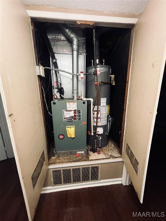 utility room featuring water heater and visible vents