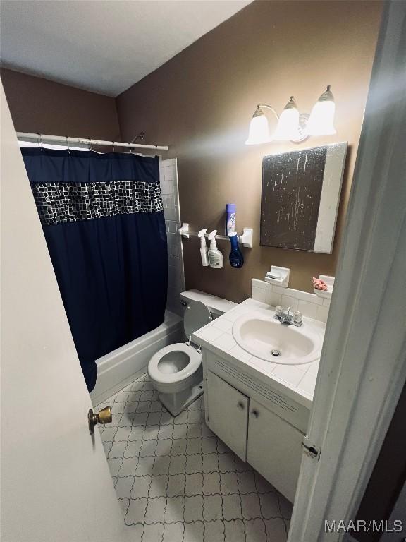 bathroom with shower / tub combo, vanity, and toilet