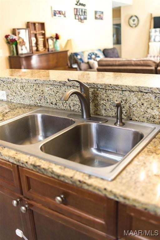 room details featuring light stone countertops and a sink