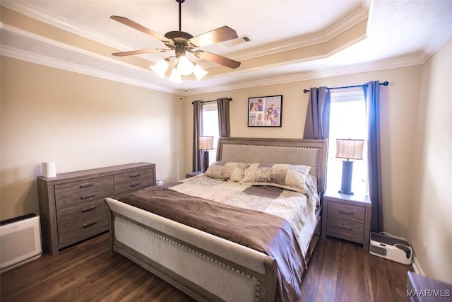 bedroom featuring visible vents, ceiling fan, ornamental molding, dark wood-style flooring, and a tray ceiling