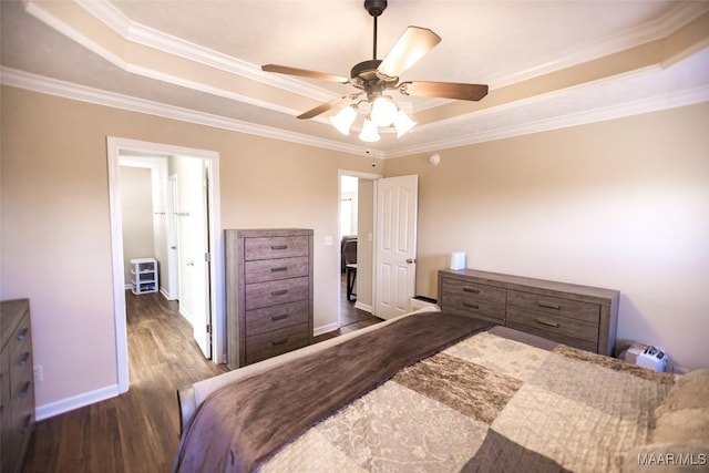 bedroom with baseboards, ceiling fan, ornamental molding, wood finished floors, and a tray ceiling