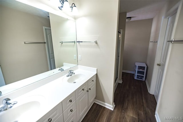 full bath featuring double vanity, wood finished floors, and a sink