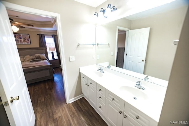 full bathroom with connected bathroom, double vanity, a sink, and wood finished floors