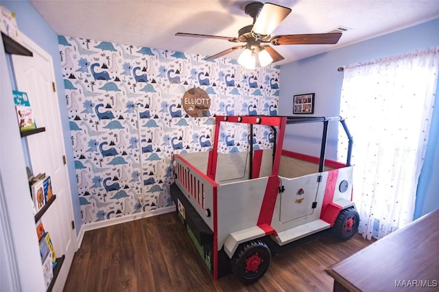 bedroom featuring a ceiling fan, visible vents, and wood finished floors