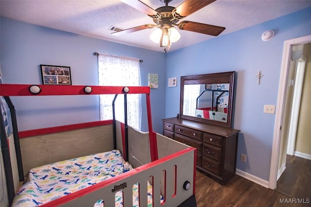 bedroom featuring baseboards, dark wood finished floors, and a ceiling fan