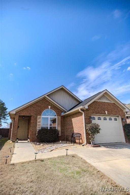 ranch-style house featuring a garage, driveway, and brick siding