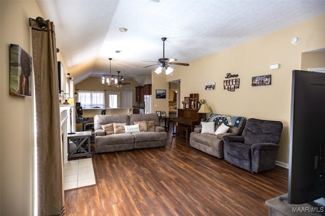 living room with lofted ceiling, dark wood-style flooring, and ceiling fan with notable chandelier