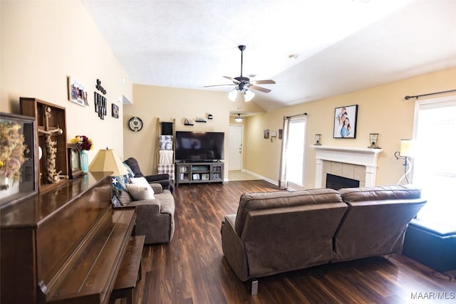 living area with baseboards, lofted ceiling, ceiling fan, wood finished floors, and a fireplace