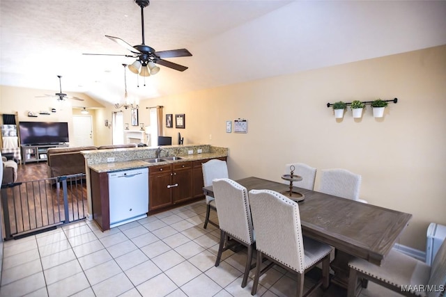 kitchen featuring a ceiling fan, lofted ceiling, a peninsula, white dishwasher, and a sink