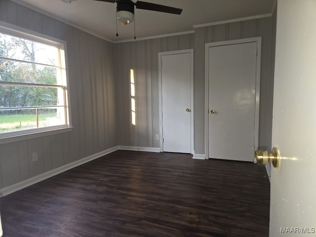 unfurnished room featuring ornamental molding, a ceiling fan, and dark wood-style floors