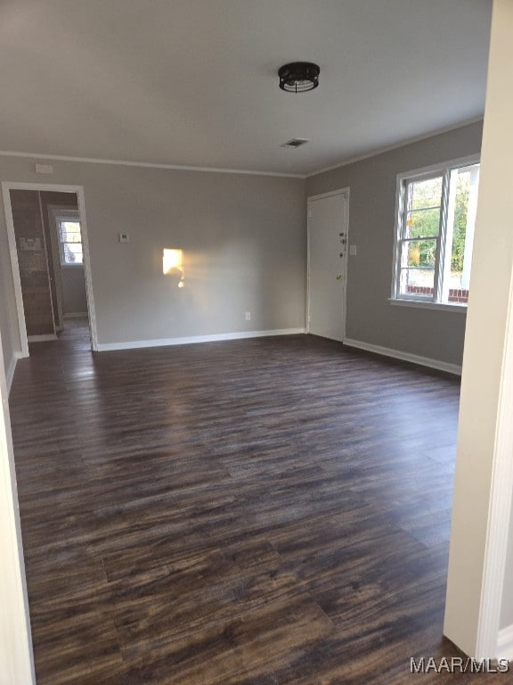 interior space with ornamental molding, dark wood-type flooring, and a healthy amount of sunlight