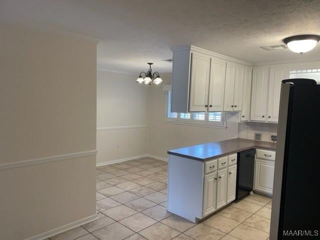 kitchen featuring visible vents, dishwasher, freestanding refrigerator, a peninsula, and crown molding