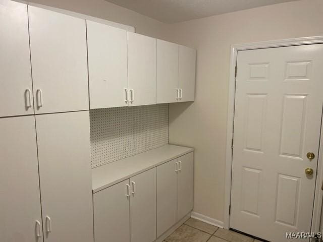 interior space featuring baseboards and light tile patterned floors