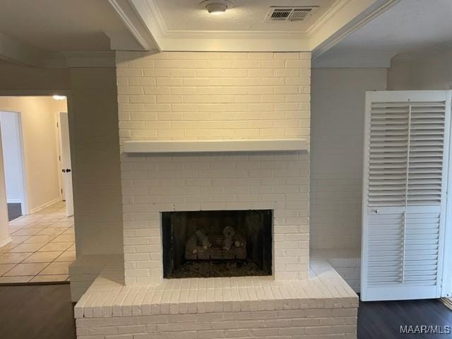 room details with ornamental molding, a fireplace, wood finished floors, and visible vents