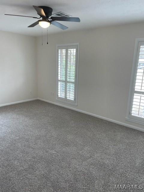 carpeted empty room with baseboards and a ceiling fan