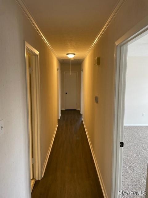 hall with attic access, ornamental molding, and baseboards