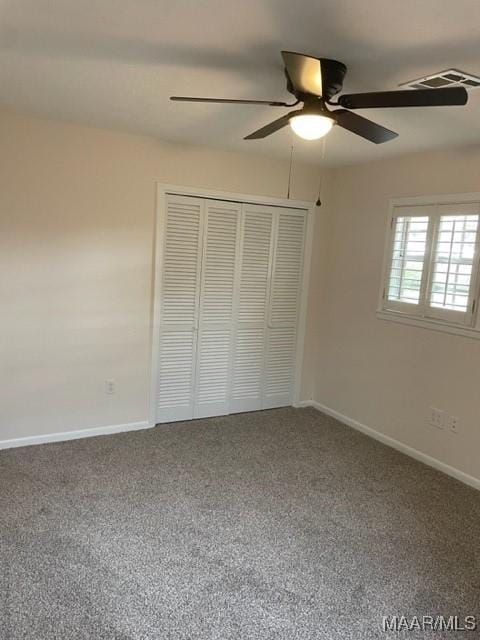 unfurnished bedroom featuring ceiling fan, carpet floors, visible vents, baseboards, and a closet