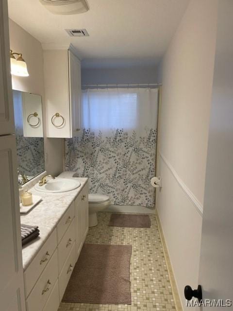 full bathroom with visible vents, curtained shower, vanity, and toilet