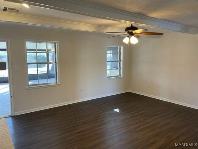 empty room featuring dark wood-style floors, visible vents, and a healthy amount of sunlight