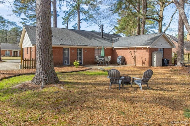 back of house with a patio area, brick siding, and a fire pit