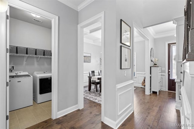 clothes washing area with laundry area, visible vents, hardwood / wood-style flooring, crown molding, and a decorative wall