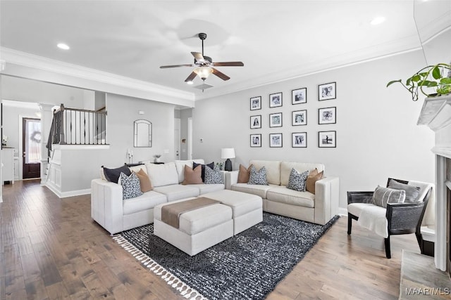 living room featuring stairs, wood finished floors, a ceiling fan, and crown molding