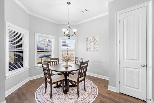 dining room with dark wood-type flooring, crown molding, baseboards, and an inviting chandelier