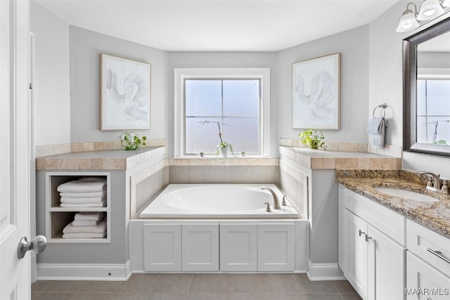 full bath featuring a garden tub, tile patterned flooring, a wealth of natural light, and vanity