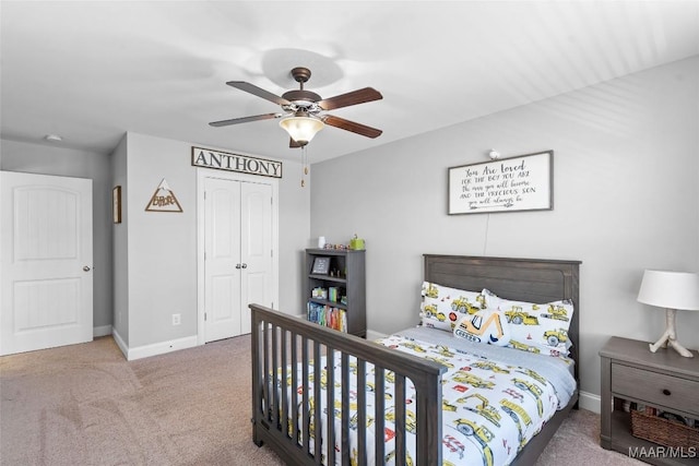 carpeted bedroom featuring ceiling fan, a closet, and baseboards