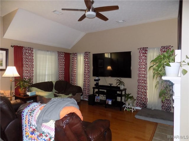 living room featuring ceiling fan, visible vents, vaulted ceiling, and wood finished floors