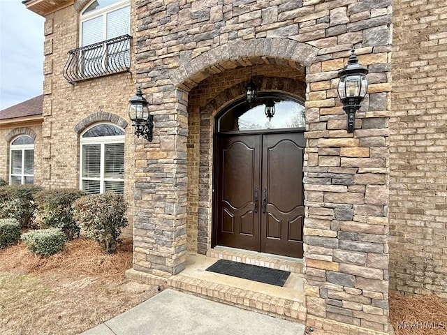 property entrance with stone siding and roof with shingles