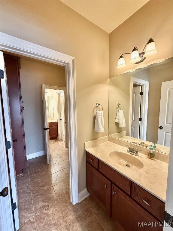 bathroom featuring tile patterned flooring, vanity, and baseboards