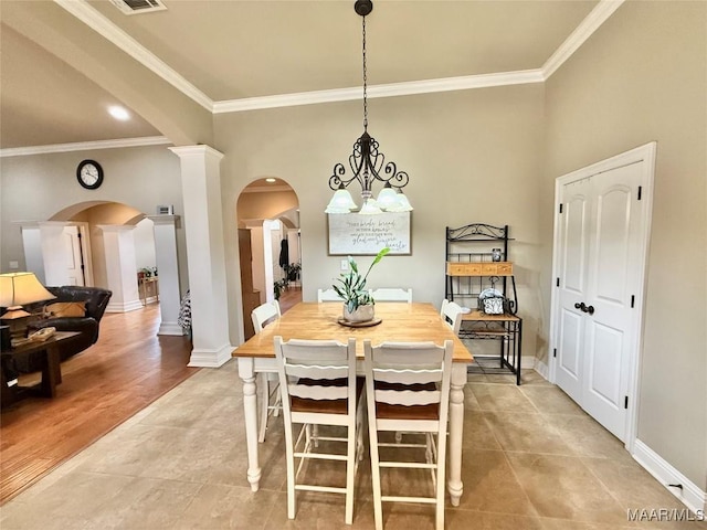 dining space with baseboards, arched walkways, and crown molding