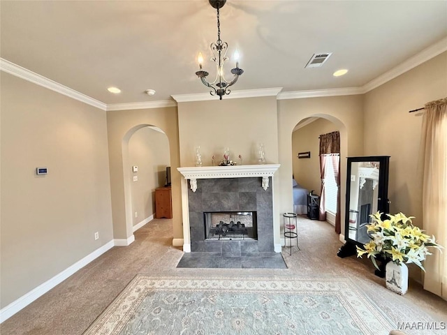 carpeted living room with arched walkways, visible vents, ornamental molding, a tile fireplace, and baseboards