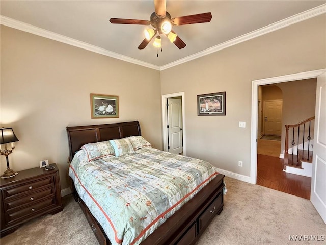 carpeted bedroom featuring baseboards, ceiling fan, arched walkways, and crown molding