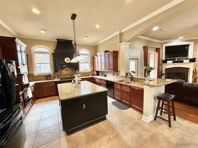 kitchen with open floor plan, a fireplace, a peninsula, and black appliances