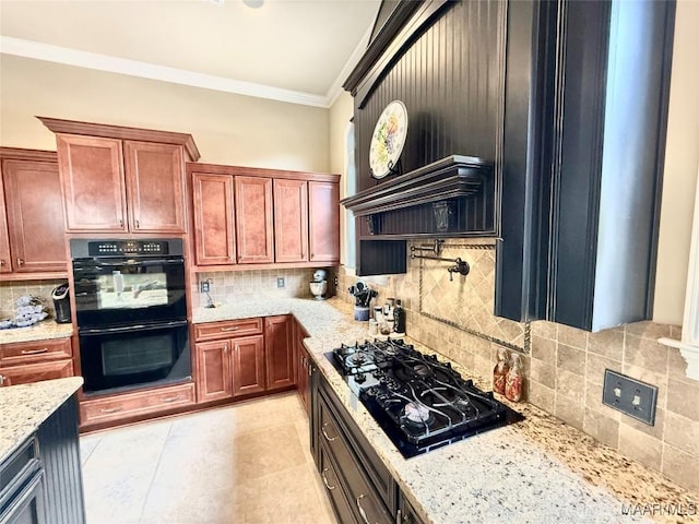 kitchen with decorative backsplash, brown cabinetry, ornamental molding, light stone counters, and black appliances