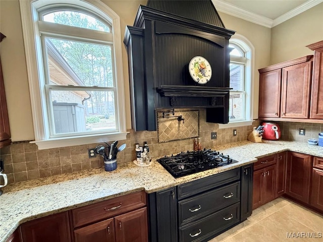 kitchen featuring black gas cooktop, tasteful backsplash, light stone countertops, and crown molding