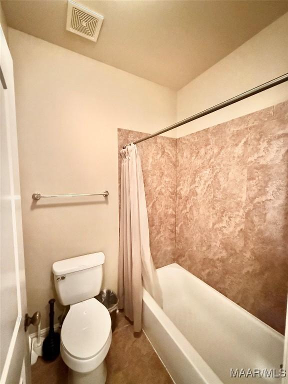 bathroom with toilet, shower / tub combo, and visible vents