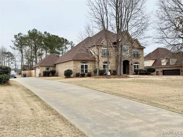 french country inspired facade with a front yard and brick siding